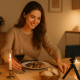 Person filming a cozy dinner setup, representing TikTok’s ‘Date With Me’ romance trend.