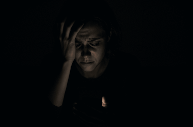 Person feeling trapped by online blackmail threats