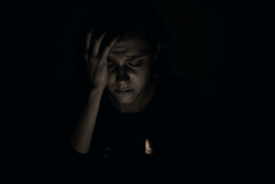 Person feeling trapped by online blackmail threats